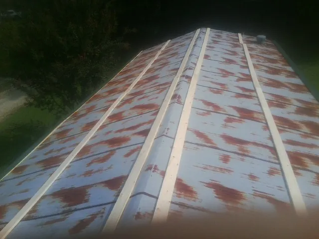 Rusted metal roof panels with new wood purlins before replacement — Storm Damage Roof Repair in Stockholm by Roofing Brothers