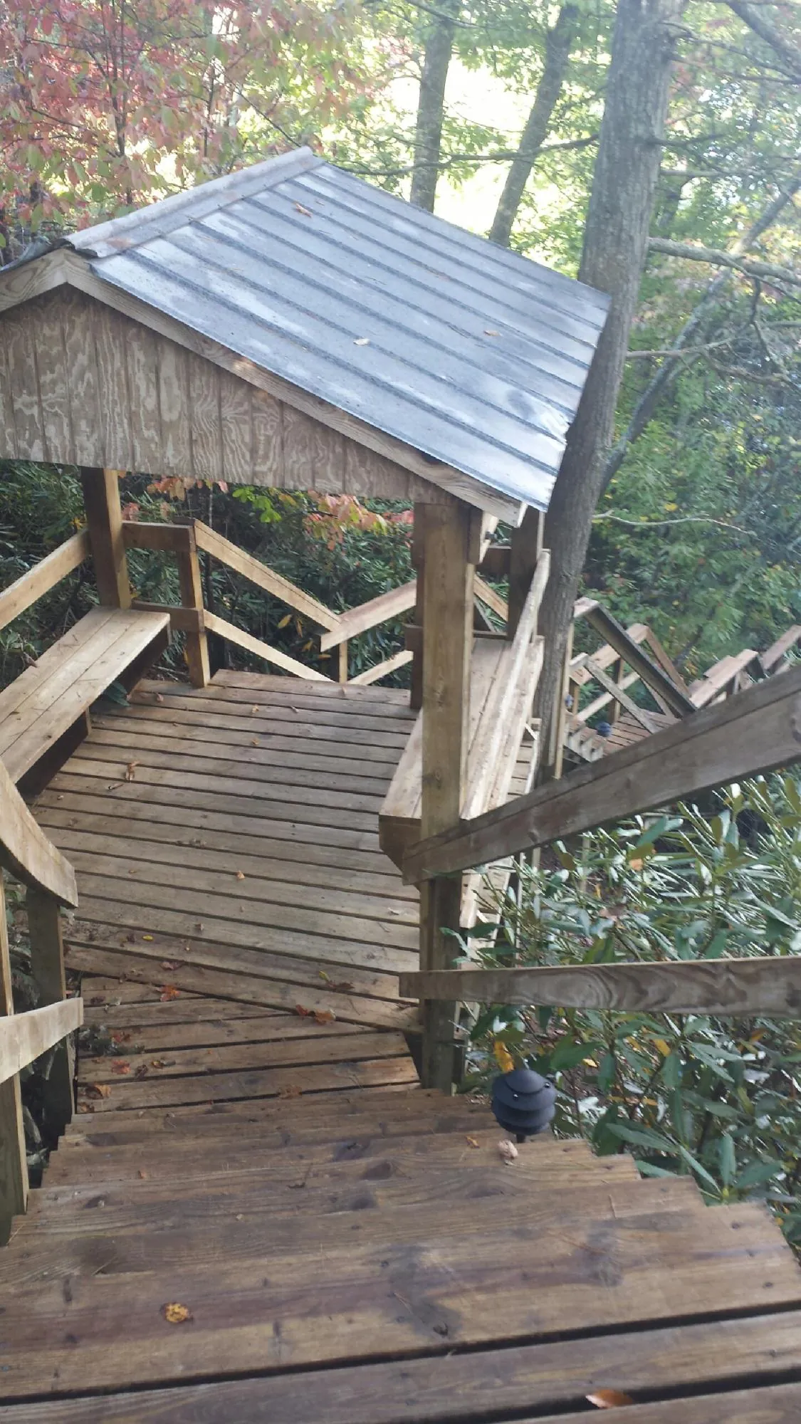 Metal roofed shelter over wooden steps on a wooded walkway — Skylight Repair & Installation work by our crew in Stockholm